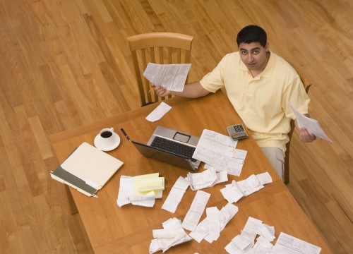 Hispanic man paying bills