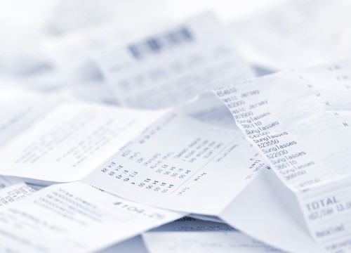 Paper cash register receipts in a lose pile close up